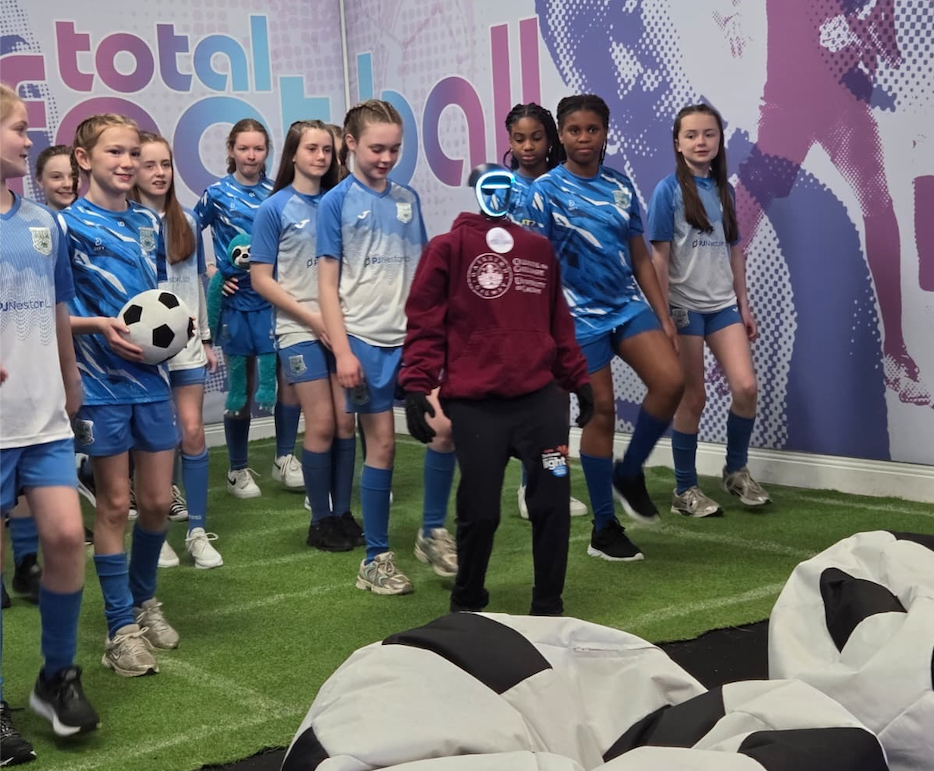girls football team with semi-humanoid robot participating in RTE programme