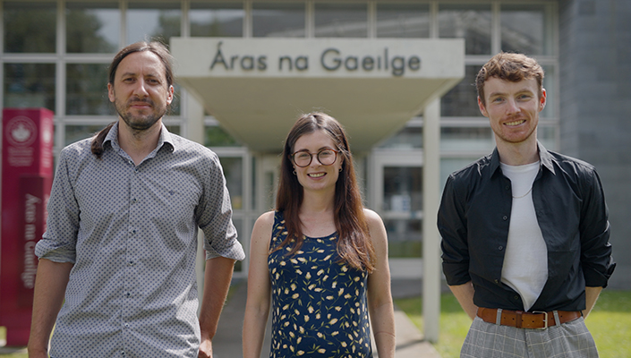 Three people standing in front of Áras na Gaeilge