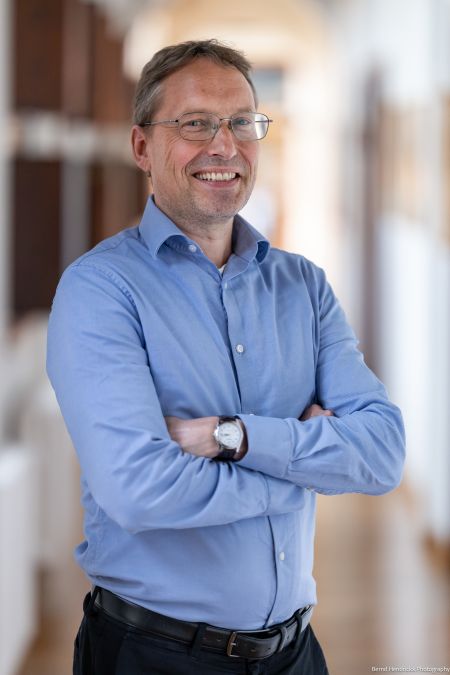 Ad Putter posed in blue shirt with arms folded