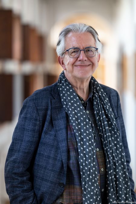 Matthias Meyer standing wearing grey jacket and scarf