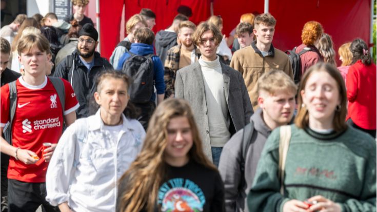 large group of students walking on campus