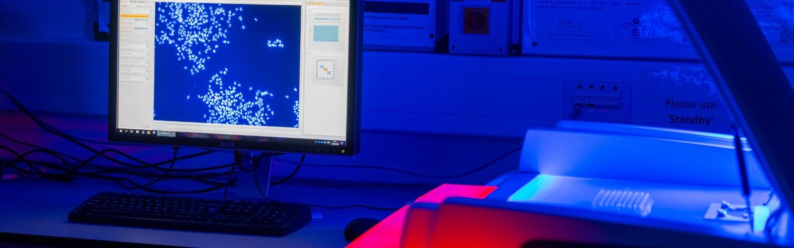 Laboratory equipment with a red light and a computer screen displaying blue image